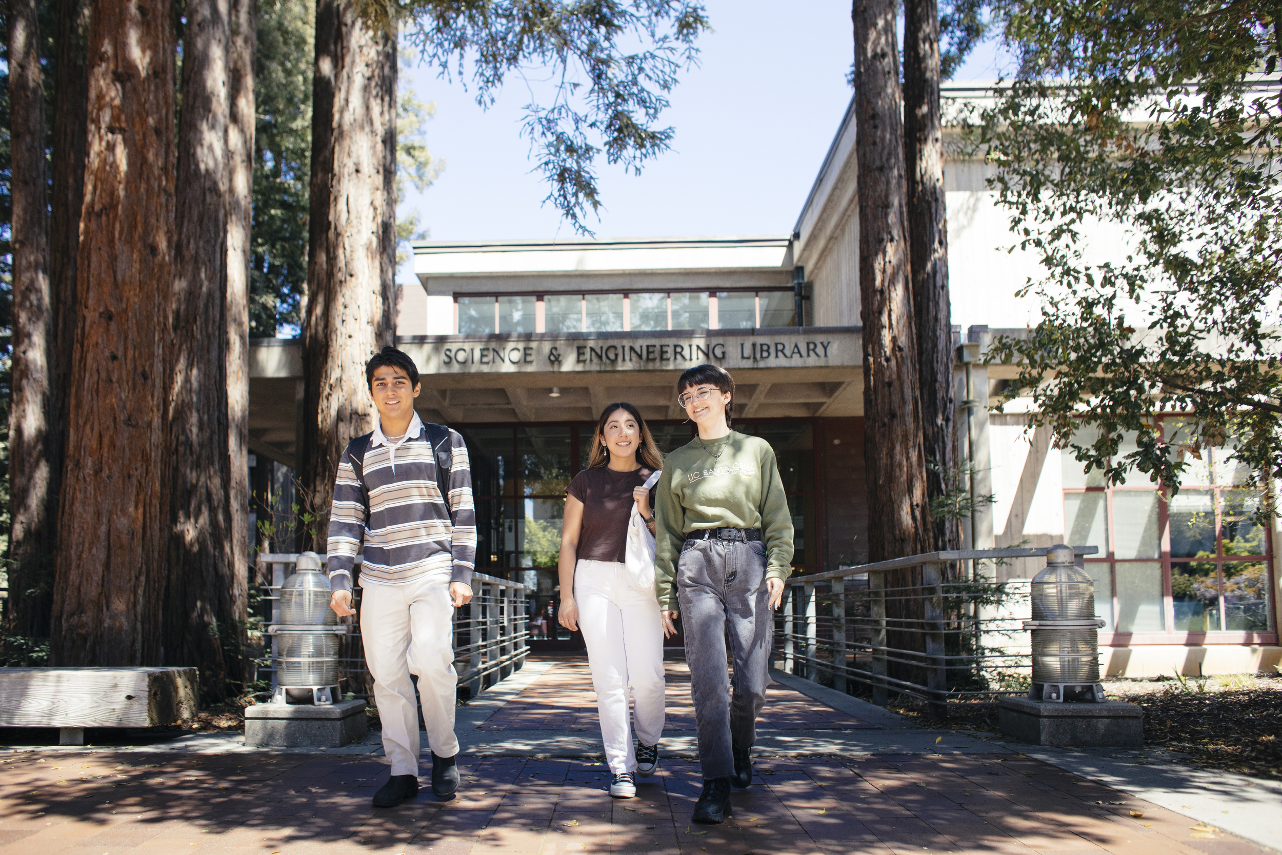 Image of three students in front of campus library 